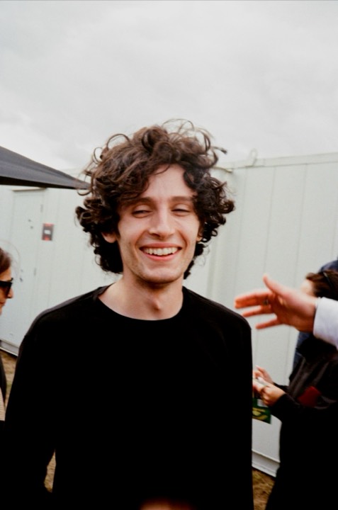 A curly-haired man laughing