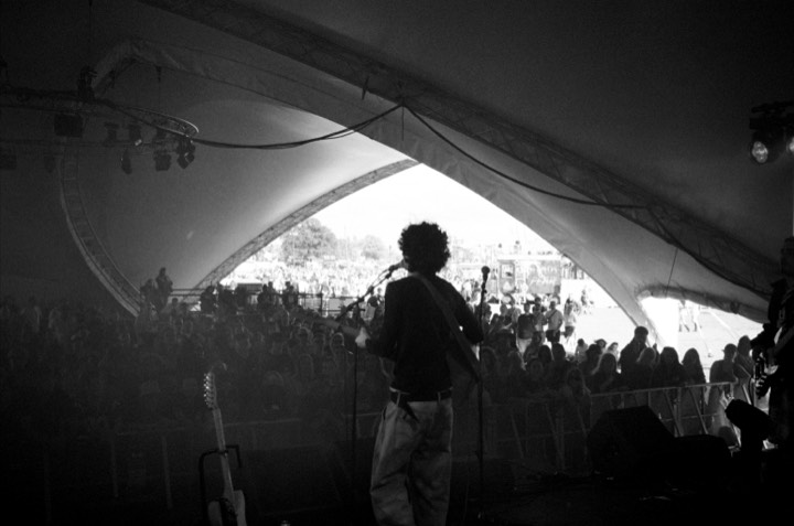 A band on stage seen from behind, in black and white