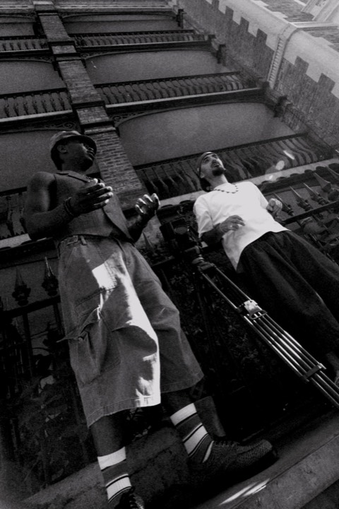 Two men leaning on the railings, shot from below, in black and white