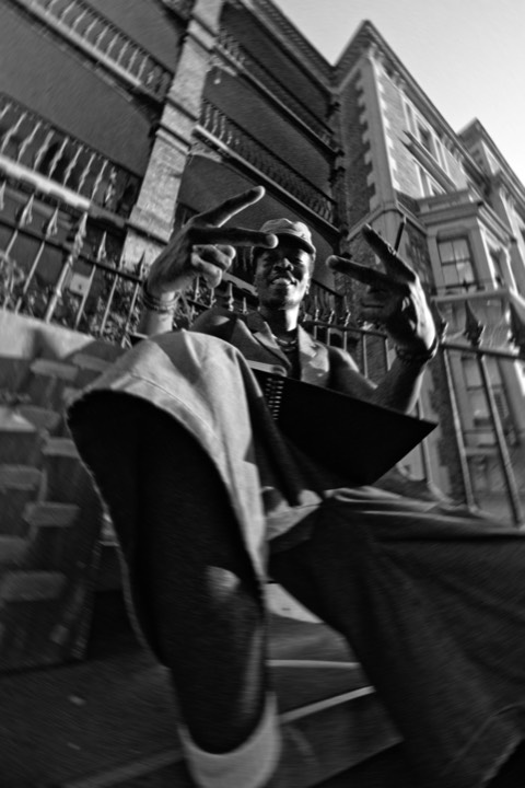 A man gesturing at the lens, low angle, in black and white