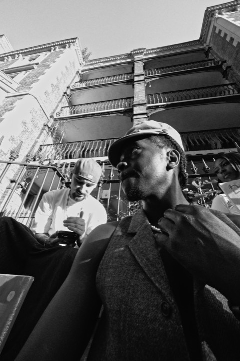 Two men by the railings, one in a cap, in black and white
